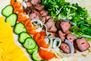 Delicious grilled meat wrap with fresh vegetables and toppings