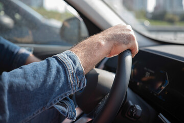 Mens hands on the streering wheel of the car