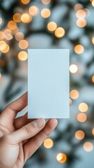 Hand holding a blank card with a cozy cafe backdrop of warm bokeh lights Generative AI
