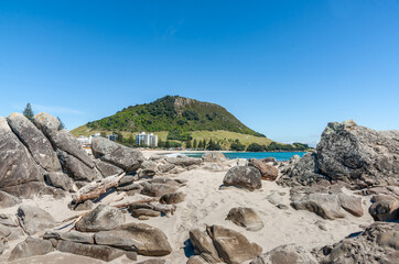 Rocky foreground on Moturiki Island on Main Beach with landmark Mount Maunganui in background.