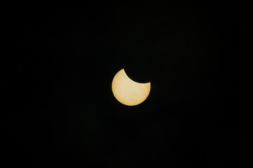 Partial solar eclipse captured against dark sky.