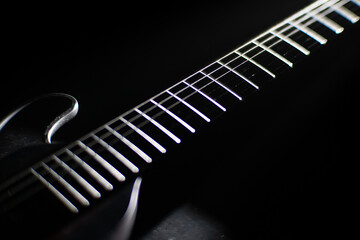 Close-up of an electric guitar, emphasizing illuminated metal frets against a dark background Shallow depth of field photography style