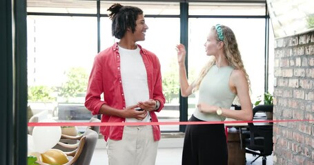 Diverse coworkers cutting red ribbon with scissors while clapping in office lobby with balloons - Powered by Adobe