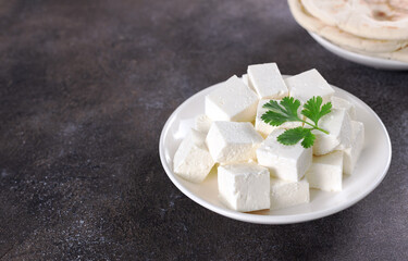 Indian paneer cheese made from fresh milk and lemon juice on grey background. Copy space. Indian...