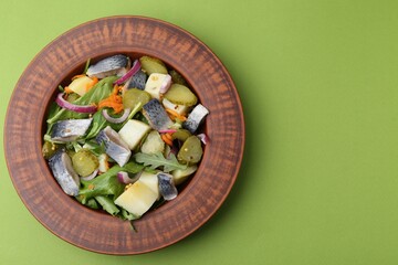 Delicious salad with herring, vegetables and mustard on green background, top view. Space for text