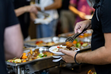 People enjoying a buffet meal with a variety of dishes in a communal dining setting during an event