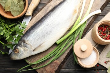 Tasty herring with spices on wooden table, flat lay