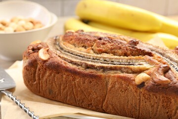 Delicious homemade banana bread with nuts, server and fruits on table, closeup