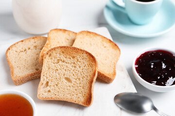 Slices of tasty toasted bread and jam on white table
