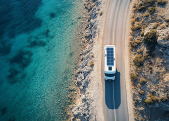 A solar-powered camper van travels along a scenic coastal road beside clear blue water. Ideal for searches about sustainable travel, road trips, and eco-friendly adventure vehicles.