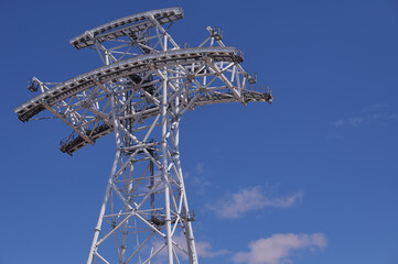 Cableway support tower against blue sky. Construction of cross-border cableway between Russia and China. Support made of white pipes in Blagoveshchensk. Concept construction technologies. Copy space.