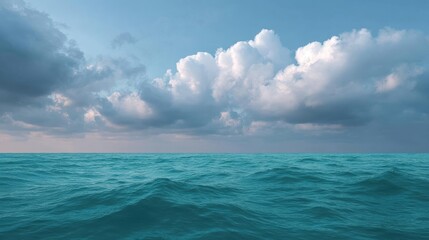 Obraz premium Landscape photograph of the ocean. the sky is a deep blue with a few white clouds scattered across it. the clouds are large and fluffy, and they appear to be floating above the water.