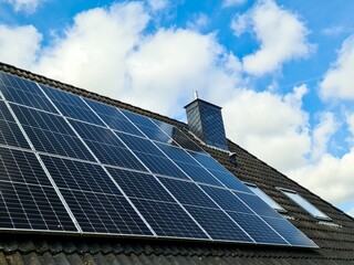Photovoltaic panels providing green energy on a roof under blue sky