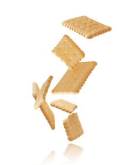 Whole and crushed crispy cookies floating in the air isolated on white background.