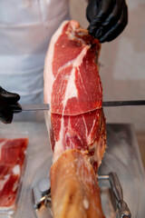 Butcher slicing iberian ham in butcher shop