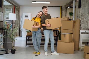 Portrait of laughing proud couple in love hold box on relocation day,