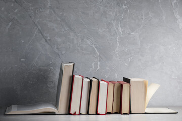 Different old books on light grey marble table