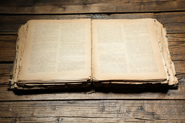 Open old book on wooden table, closeup