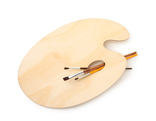 Wooden palette and brushes isolated on white, top view