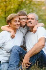 Fototapeta premium Grandfather grandmother and grandson having fun outdoors in park