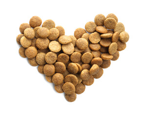 Heart shape made of dry pet food isolated on white, top view