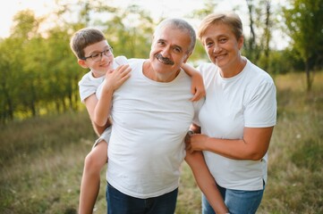 Grandparents and grandson together in autumn park