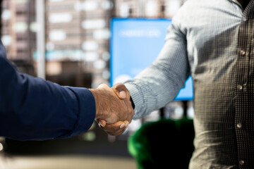 Fototapeta premium Company manager attending briefing meeting with CEO to share new ideas for profit growth, shaking hands, finalizing deal. Close up of man talking to director, doing handshake reaching agreement