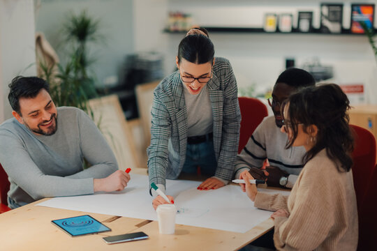 Creative business team drawing on paper during brainstorming meeting