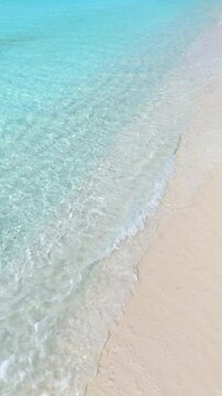 Top view of tropical beach with white sand and clear blue ocean turquoise water in natural sunlight, minimalist peaceful scenery background, relaxation, hotel, summer escape, Maldives island vacation