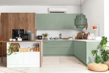 Interior of light kitchen with modern appliances on wooden table