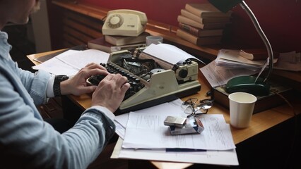 Thoughtful young writer in smoky vintage office, cinematic soft focus on typewriter and scattered...
