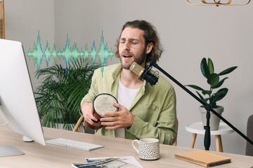Young man with drum singing in microphone at home