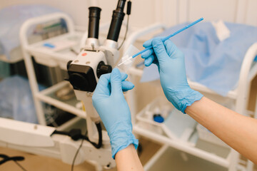 Gynecologist prepares vaginal smear for bacterial examination. Preparing gynecological equipment for procedure.