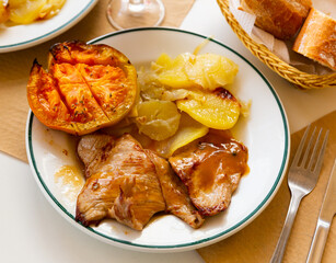 Appetizing pork in sauce with baked potatoes and grilled tomato