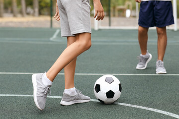 Obraz premium Boy with his dad playing football on soccer pitch