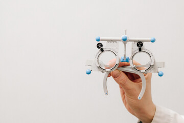 Trial frame glasses in ophthalmologist hands on white background. Trial glasses frame eye visual...
