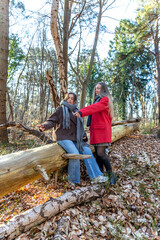 Two female friends on a walk in the forest. Friends walking through the forest. People in nature.