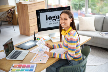 Female graphic designer with drawing working at table in office