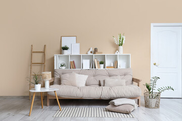 Cozy sofa, shelving unit and coffee table in interior of living room