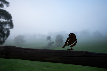 metal art in the shape of a bird on a fence