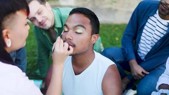 Black man doing makeup with friends. Lgbt fashion concept