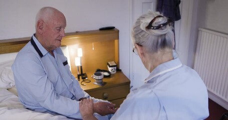 Senior man, rehab and checkup with caregiver taking pulse, blood pressure or sugar level. Elderly male in support, visit or diabetic at home with woman nurse monitoring health or wellness in bedroom