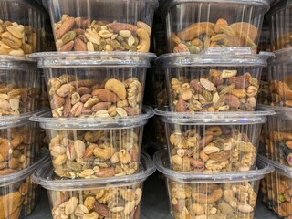 Stacked plastic containers, Assorted roasted nuts, Cashews and peanuts, Transparent packaging, Bulk food display