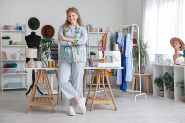 Female fashion designer with tape measures in studio