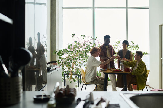 Diverse Friends Eating Lunch and Chatting in Spacious Kitchen