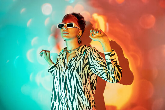 Young woman posing in zebra print with vibrant lighting