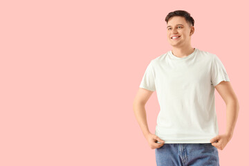 Obraz premium Young man in white t-shirt on pink background