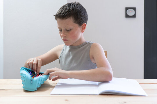 Young Boy Organizing School Supplies at Study Desk