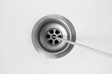 Cleaning of drain with plumber's snake, closeup