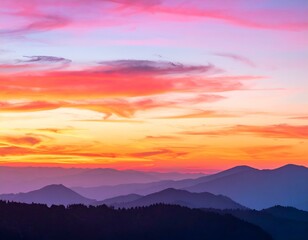 Obraz premium Vibrant sunset over layered mountains. Image depicts a breathtaking panoramic view of mountain ranges silhouetted against a fiery sunset sky.